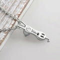 Close-up of cat urn necklace belly engraving with name and paw print, screw cap visible at neck for ashes cavity