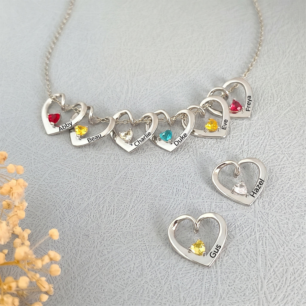 Eight rhodium heart birthstone pendants showing full multi-pet family set with varied birthstone colors