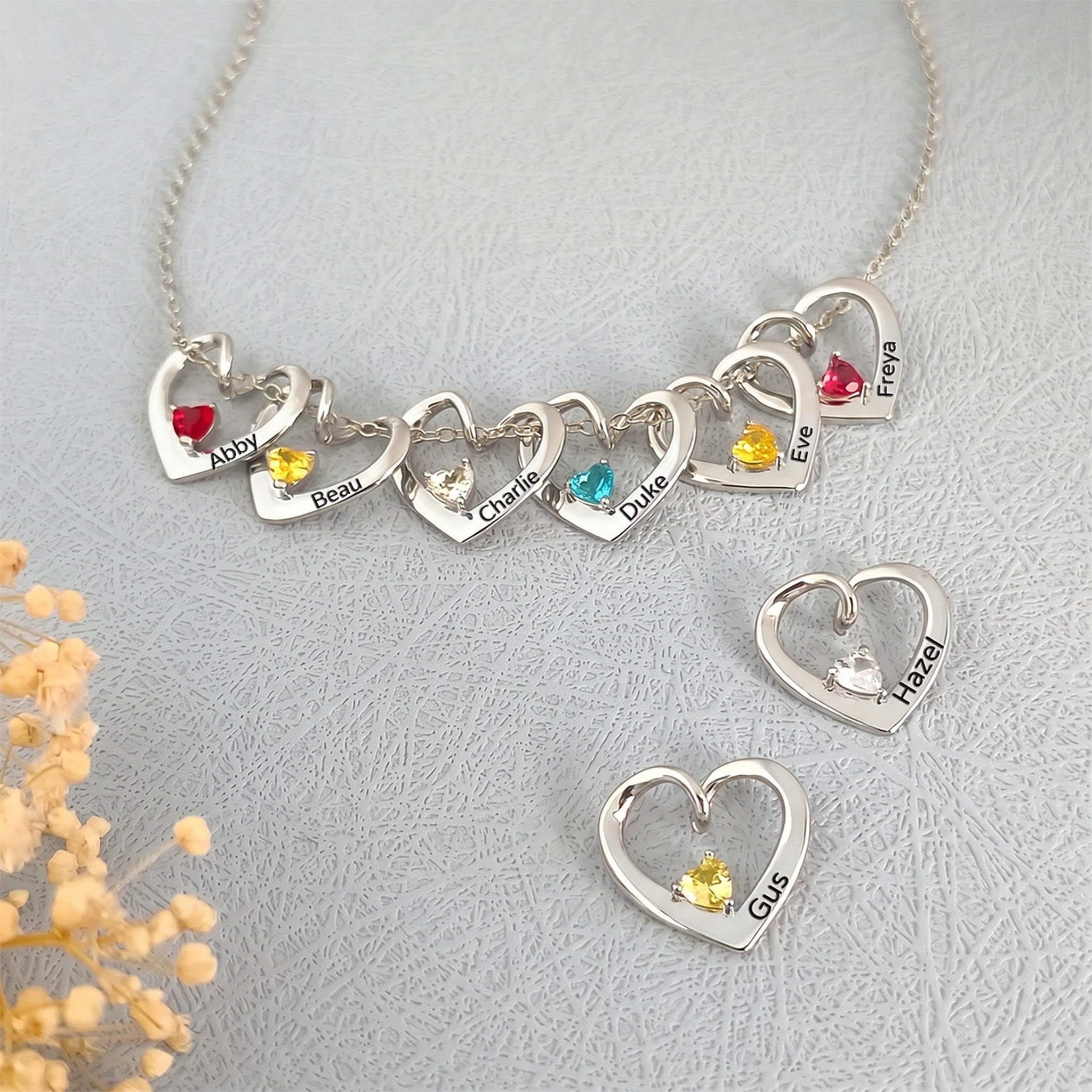 Eight rhodium heart birthstone pendants showing full multi-pet family set with varied birthstone colors