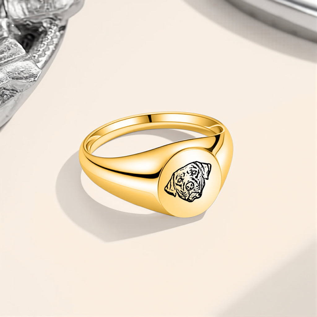 Gold pet portrait signet ring with laser-engraved portrait displayed on a beige surface