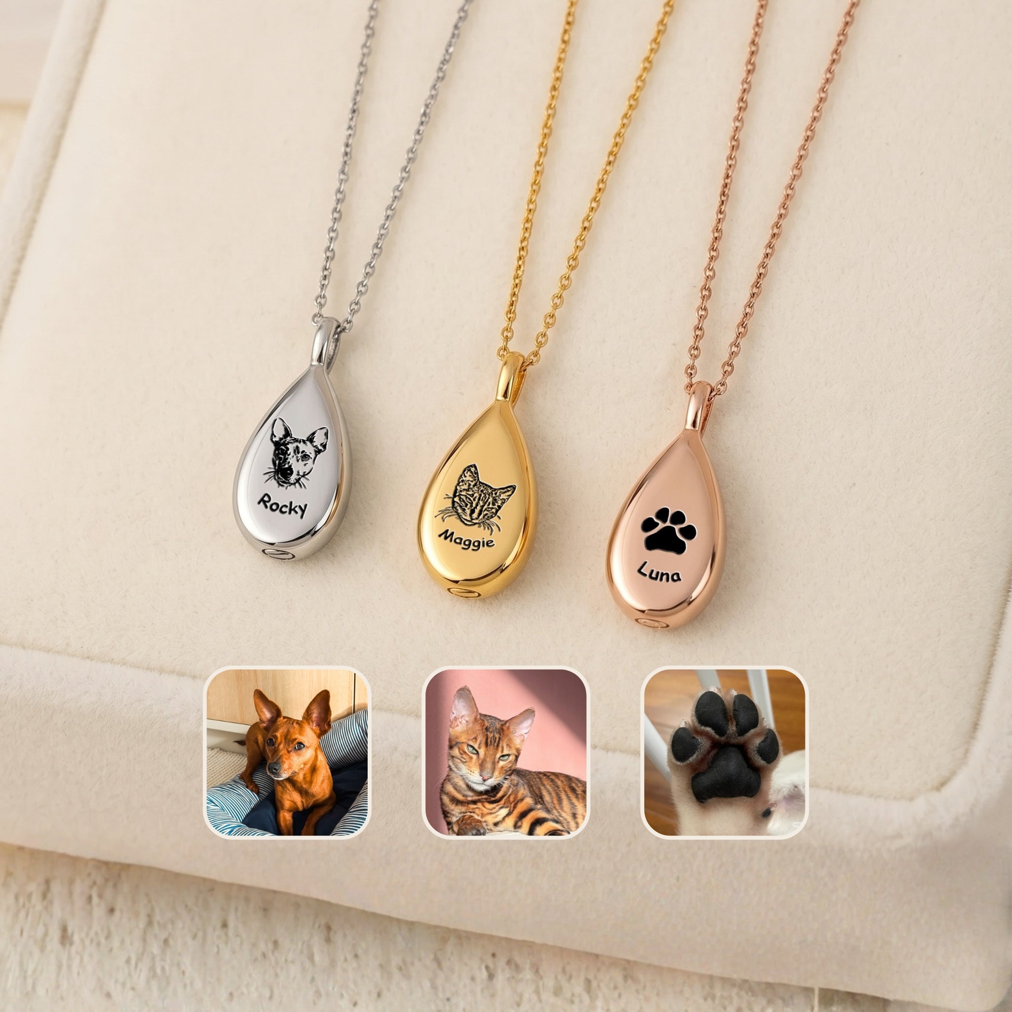 Three teardrop pet urn necklaces in silver, gold, and rose gold with dog and cat portrait engravings on cream fabric