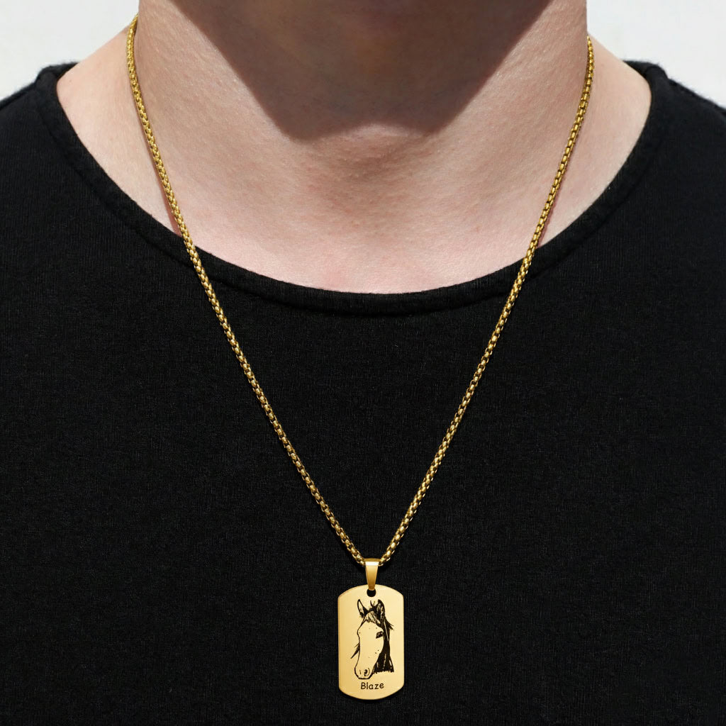 Person wearing gold pet portrait dog tag pendant necklace over black shirt, lifestyle front view