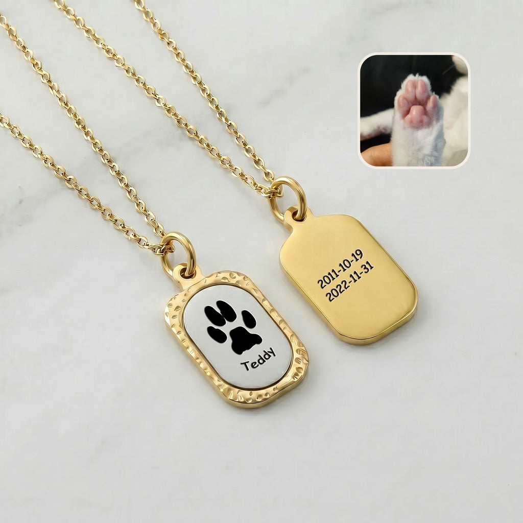 Front and back view of 18K gold vintage tag pendant showing paw print engraving on front and memorial dates on back