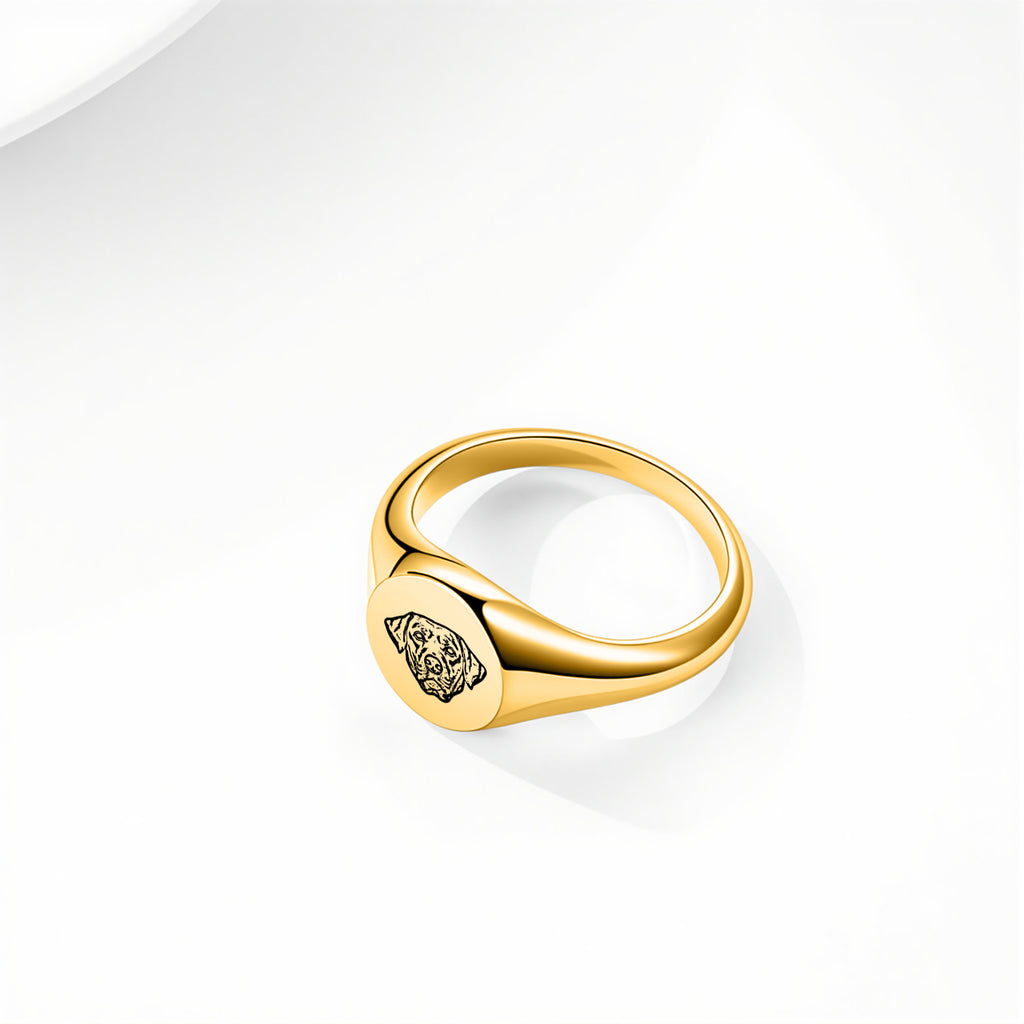 Gold signet-style pet face ring with hand-drawn portrait engraving on a white background with soft shadow
