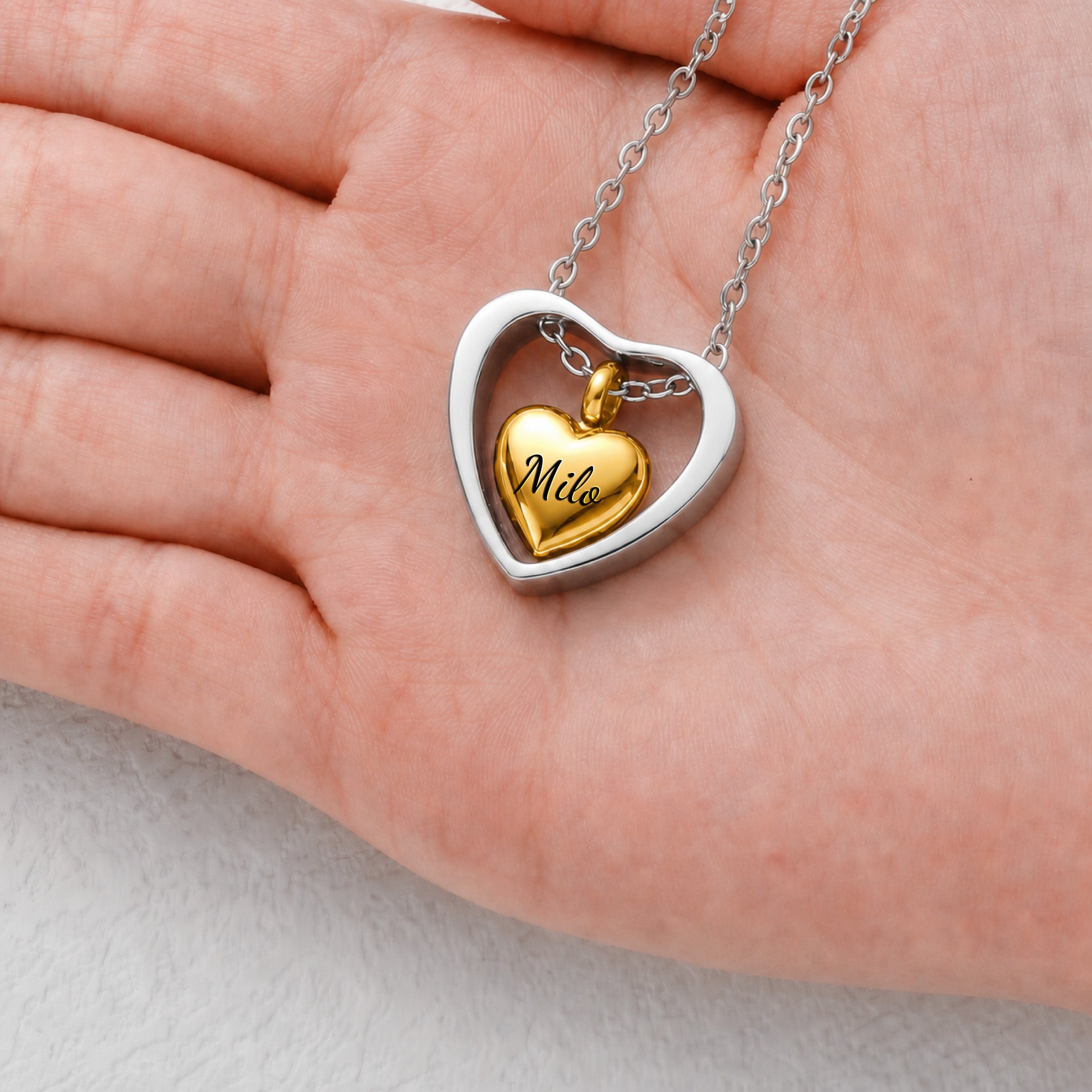Gold heart urn cremation pendant shown in hand for size reference, 20mm open heart frame