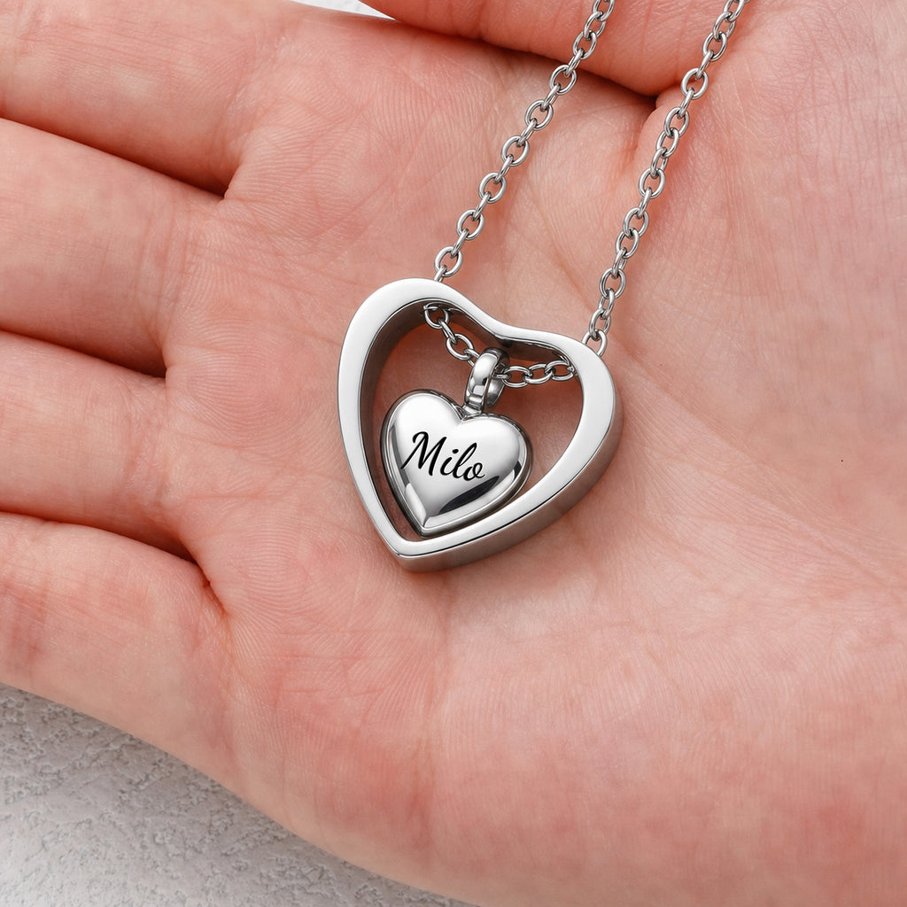 Rhodium heart urn cremation pendant shown in hand for size reference, 20mm open heart frame