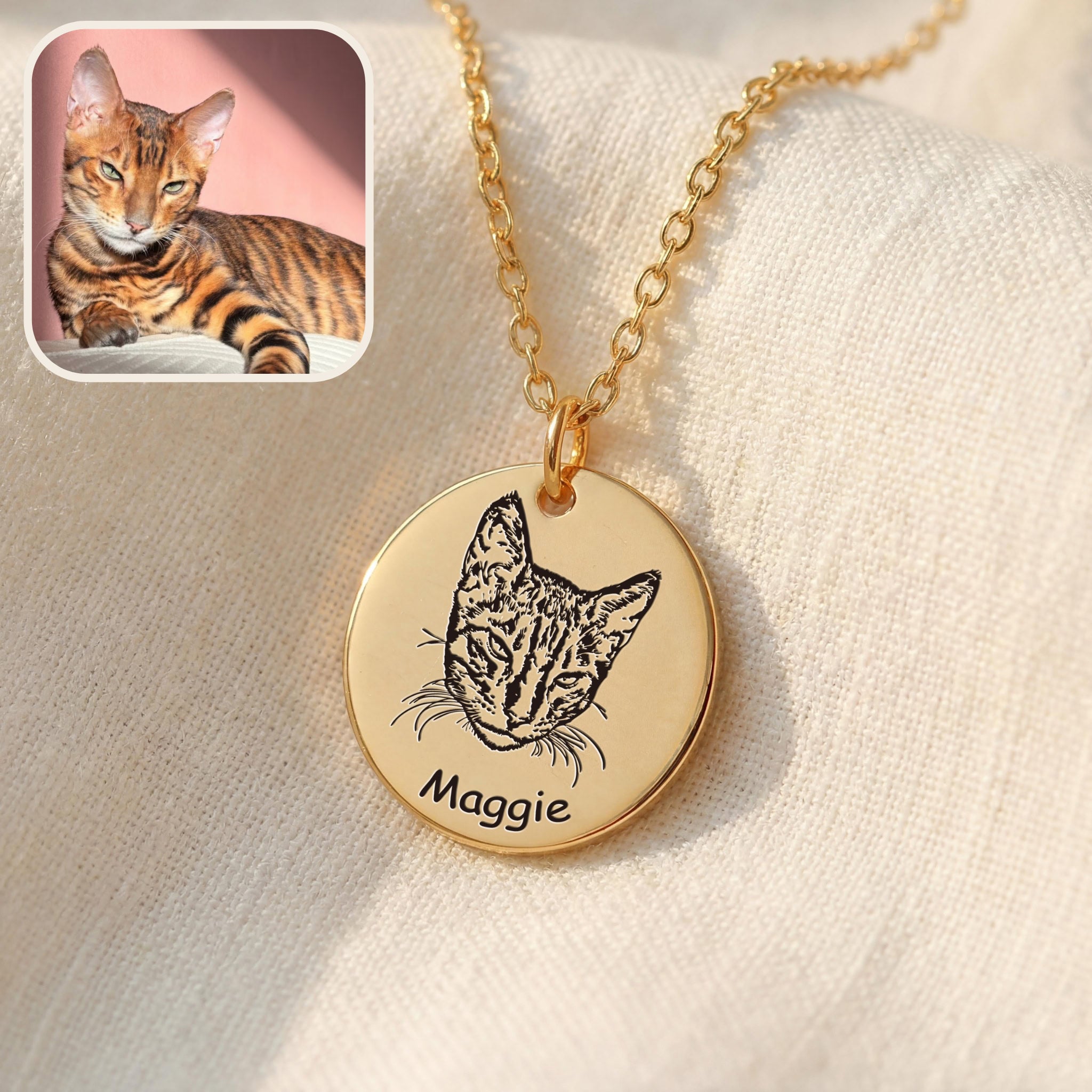 Gold disc pendant necklace with hand-drawn cat portrait engraving and name, on soft fabric
