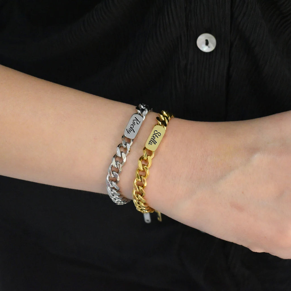 Personalized pet name bracelets in 18K gold and rhodium silver stacked on a wrist, each engraved with a name in script