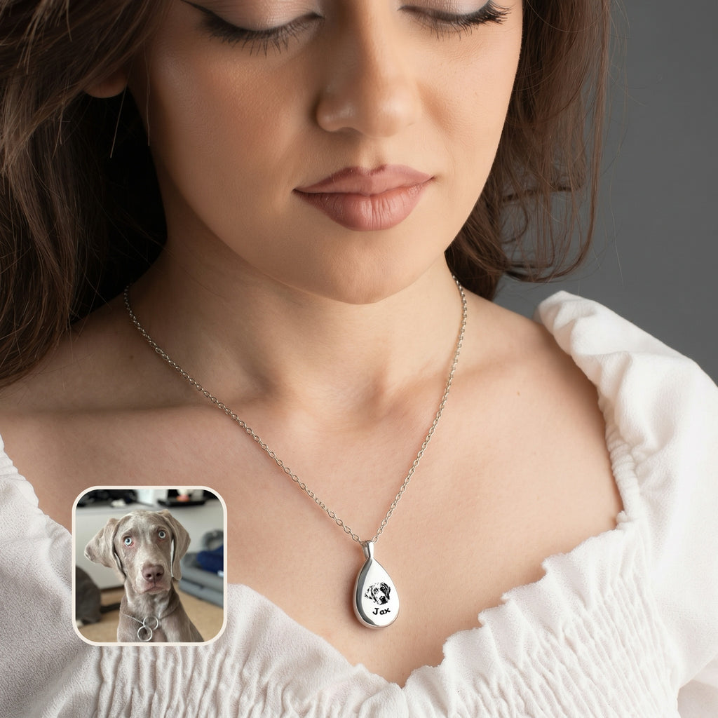 Woman wearing silver teardrop pet urn necklace with dog portrait pendant over white blouse, lifestyle view