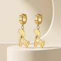 Pair of gold dog-silhouette name earrings on a cream pedestal