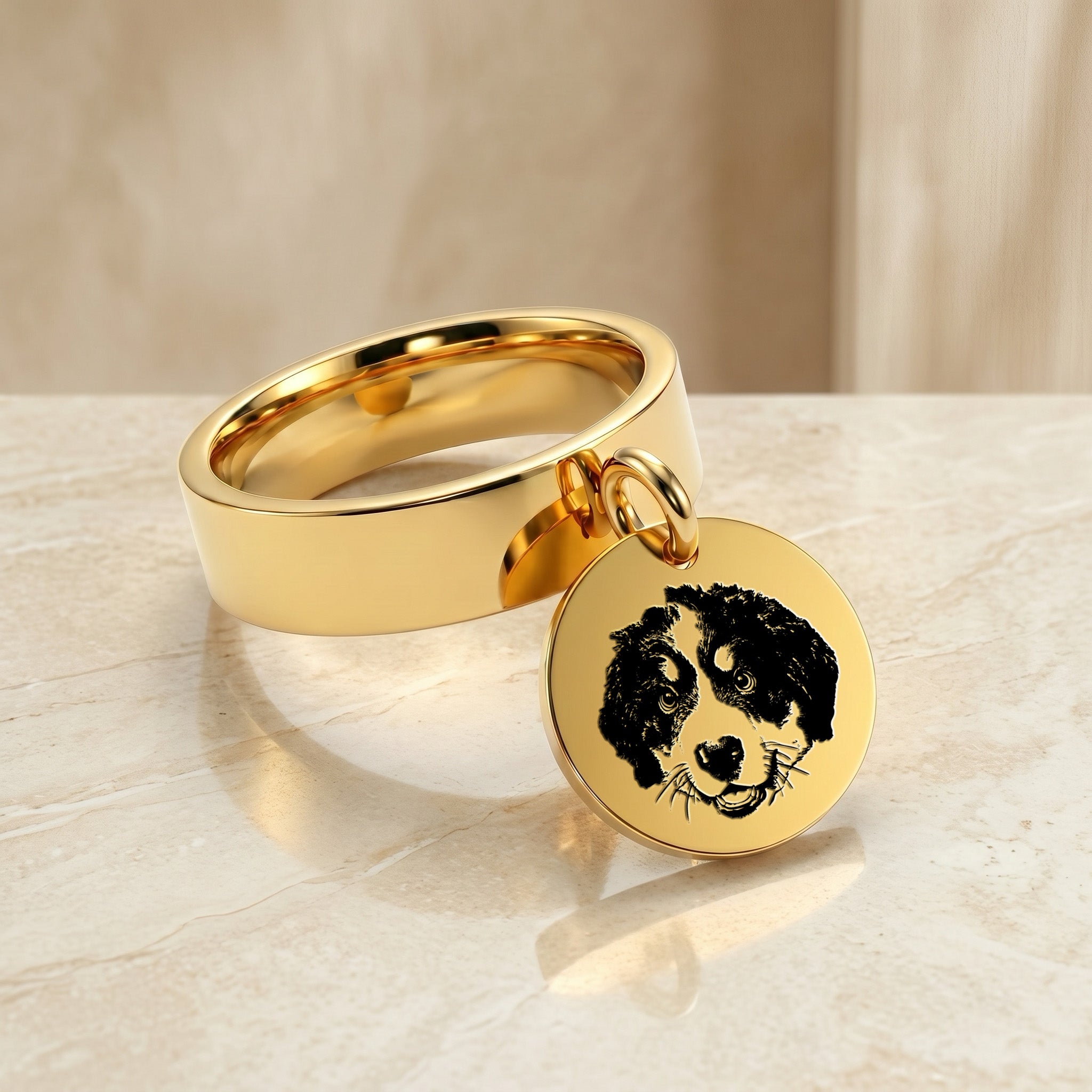 Yellow-gold disc-charm ring with a hand-drawn dog portrait, styled on a pale marble surface