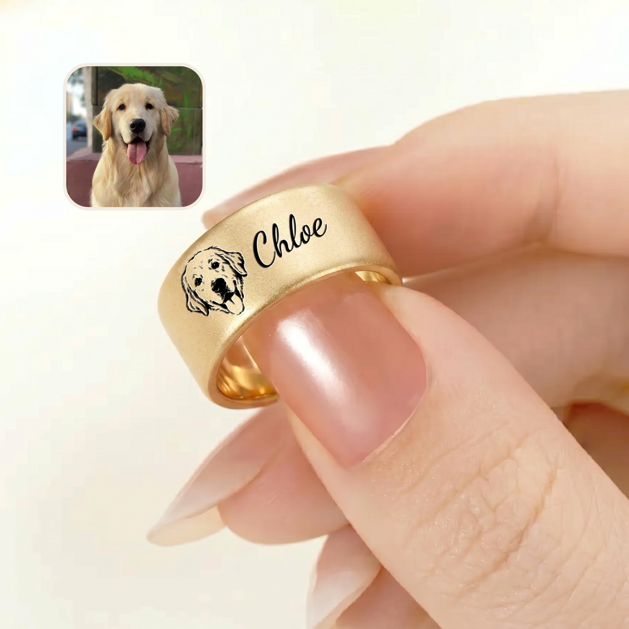 Gold wide band pet ring held between fingers, engraved portrait and script name, with a golden retriever reference photo