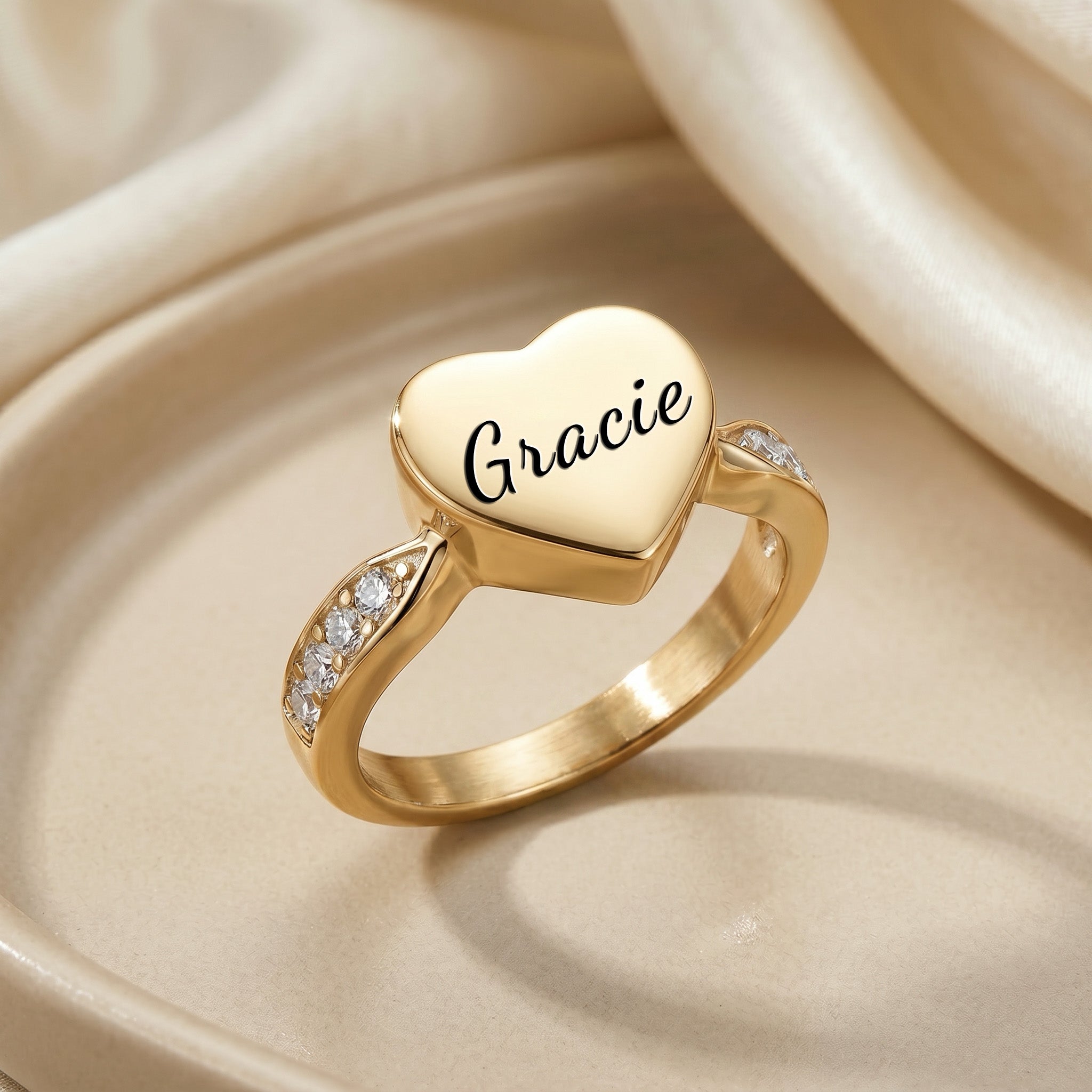 Gold heart urn ring on satin fabric, three-quarter angle showing heart depth and band profile