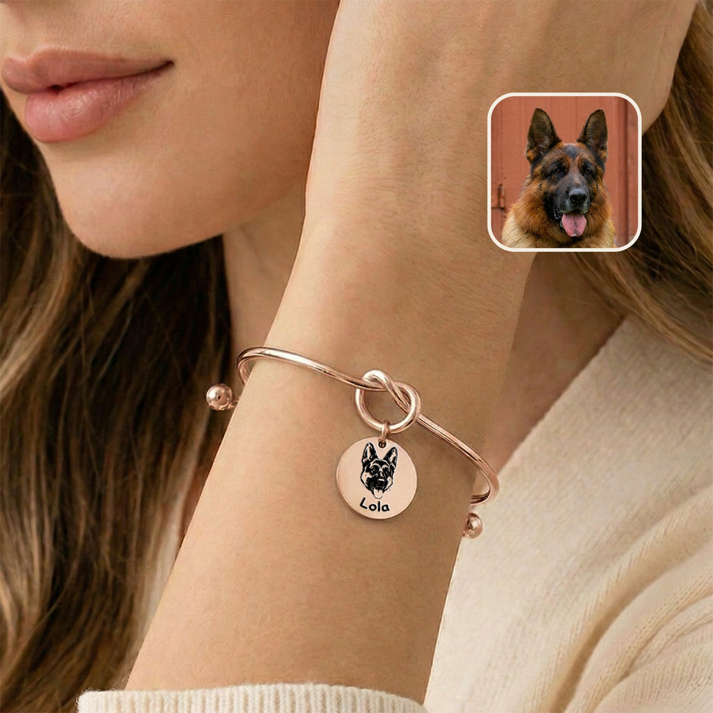 Rose gold knot cuff bracelet with engraved German shepherd portrait charm worn on a wrist near the face, photo inset