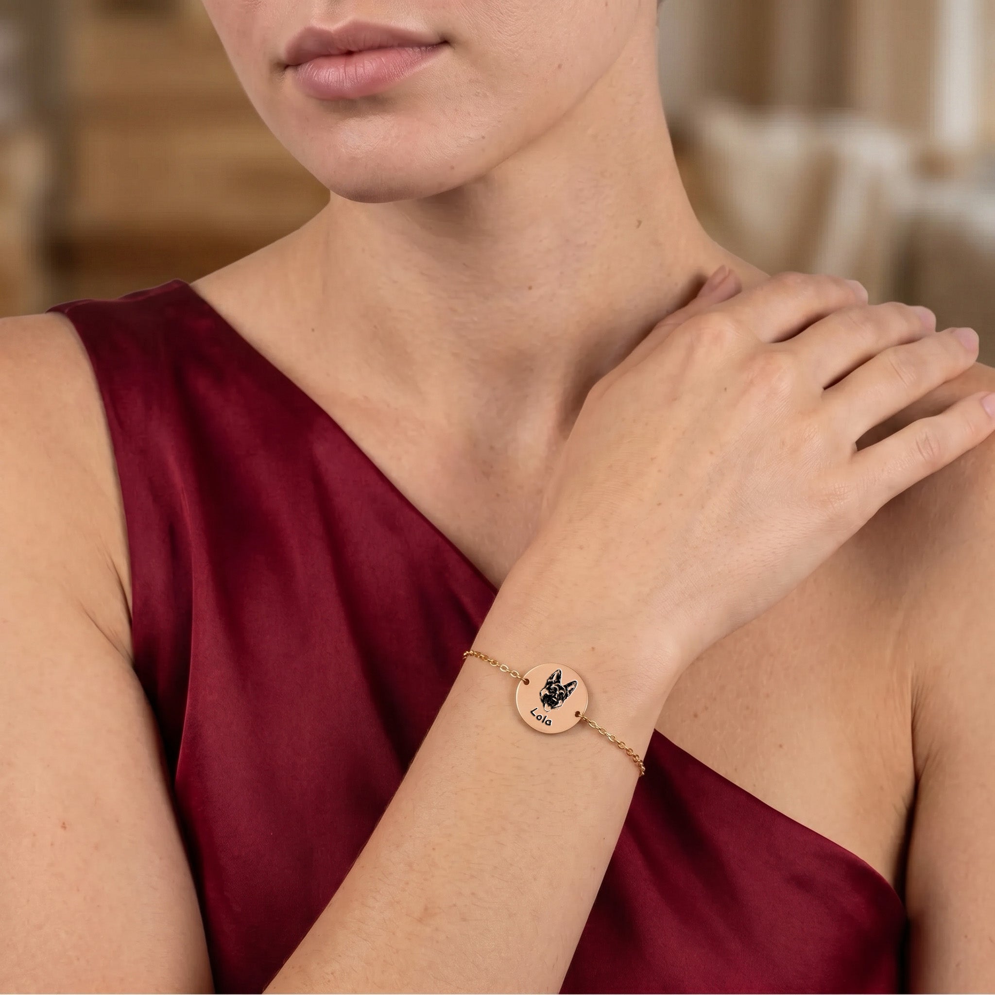 Rose gold pet portrait chain bracelet worn on a wrist against burgundy fabric, hand-drawn French Bulldog portrait on disc