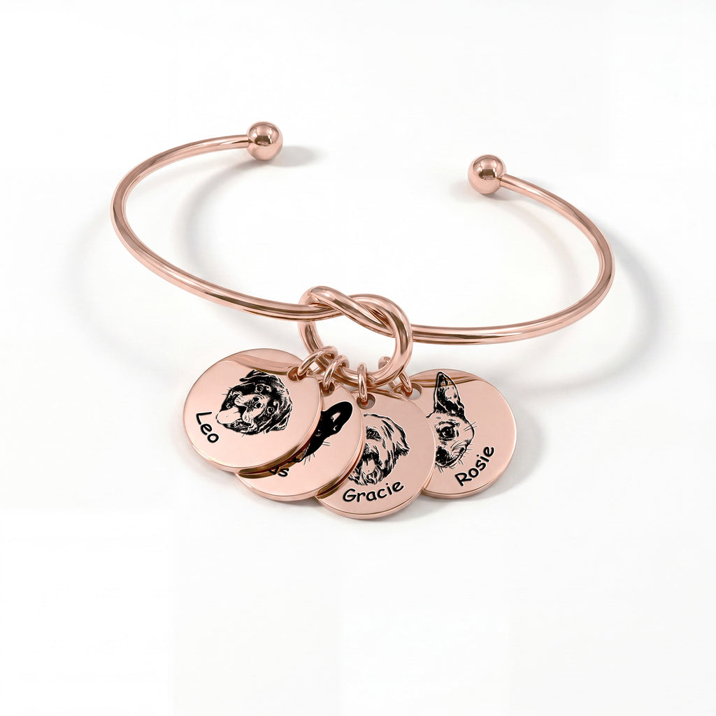 Rose gold knot cuff bracelet with four engraved pet portrait disc charms on a white background