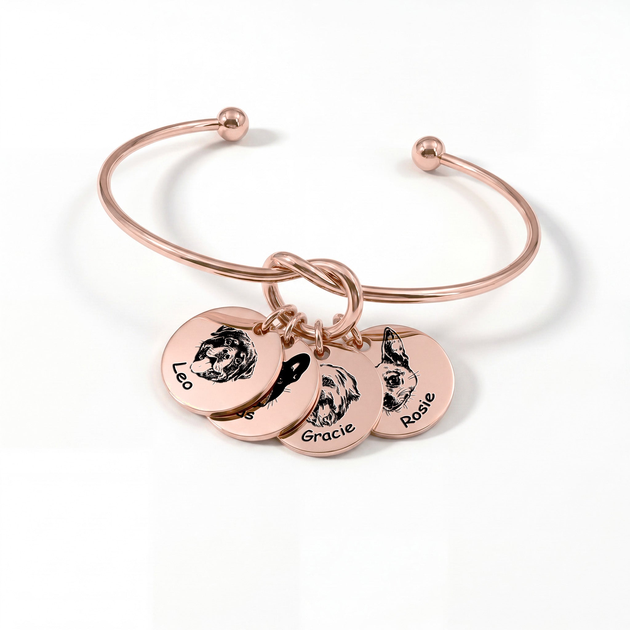 Rose gold knot cuff bracelet with four engraved pet portrait disc charms on a white background