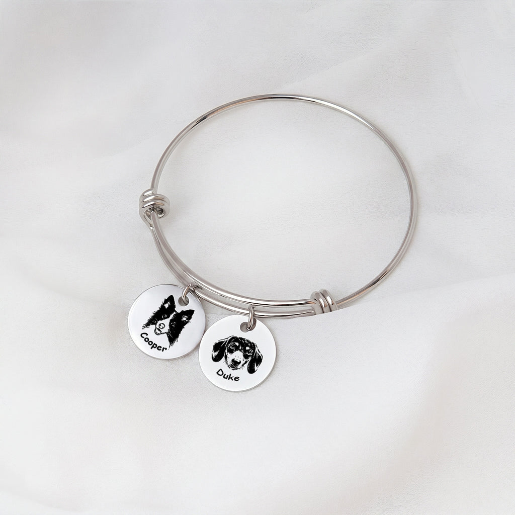 Rhodium silver personalized pet bracelet with two engraved portrait disc charms on white fabric