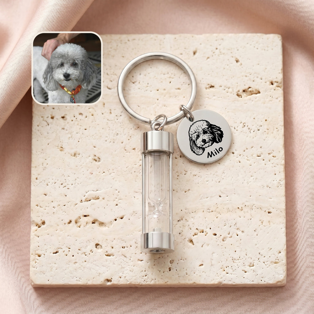 Rhodium-plated pet portrait hourglass keychain on travertine stone with engraved poodle portrait disc and glass hourglass urn, with reference photo inset