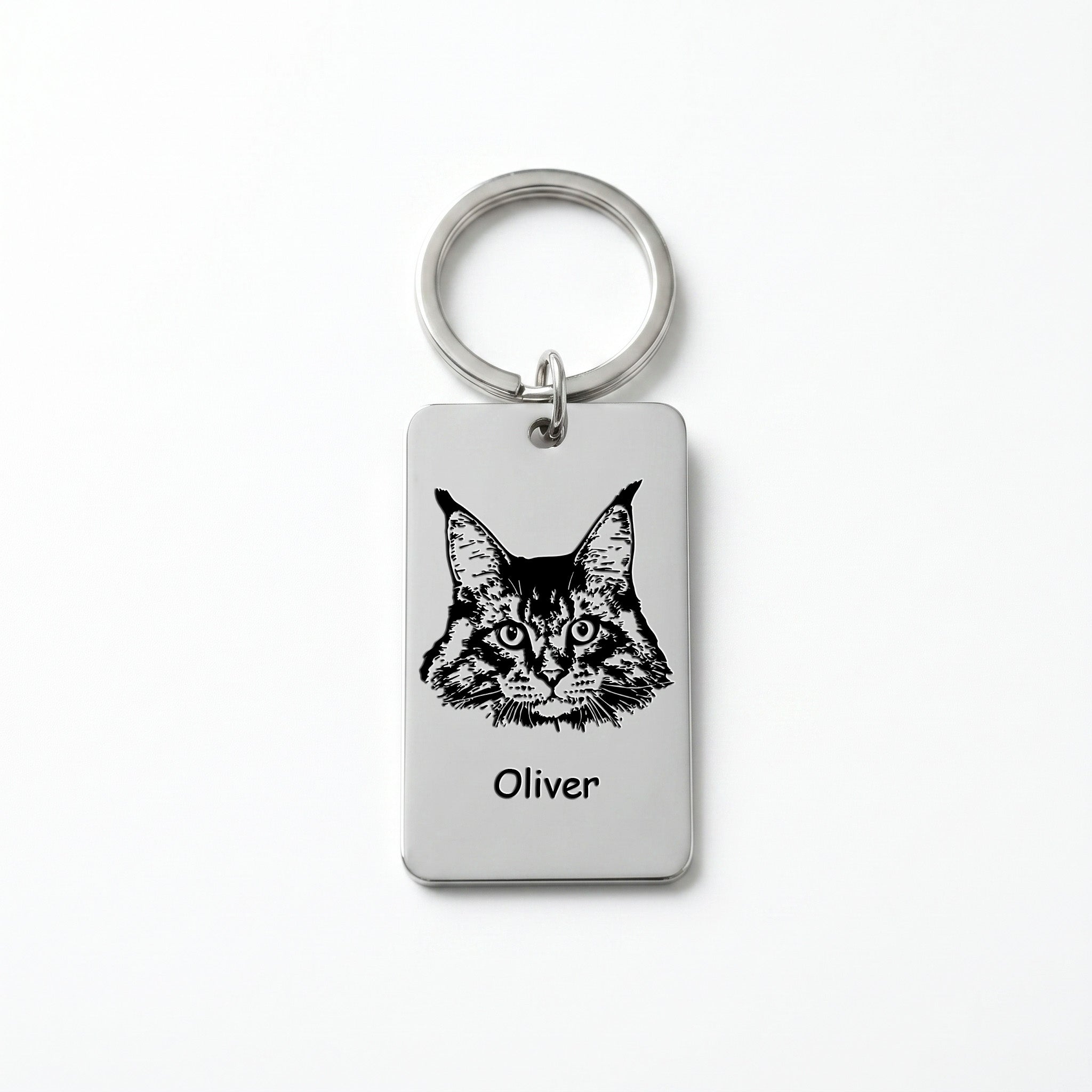 Rhodium pet portrait plate keychain on white background, Maine Coon cat portrait and name 'Oliver' laser-engraved on the rectangular steel plate