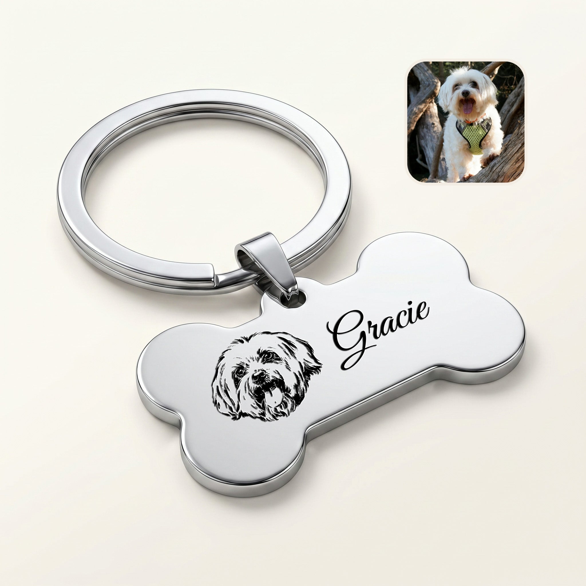 Rhodium pet bone keychain close-up — hand-drawn portrait + pet name in Great Vibes script laser-engraved on the front face