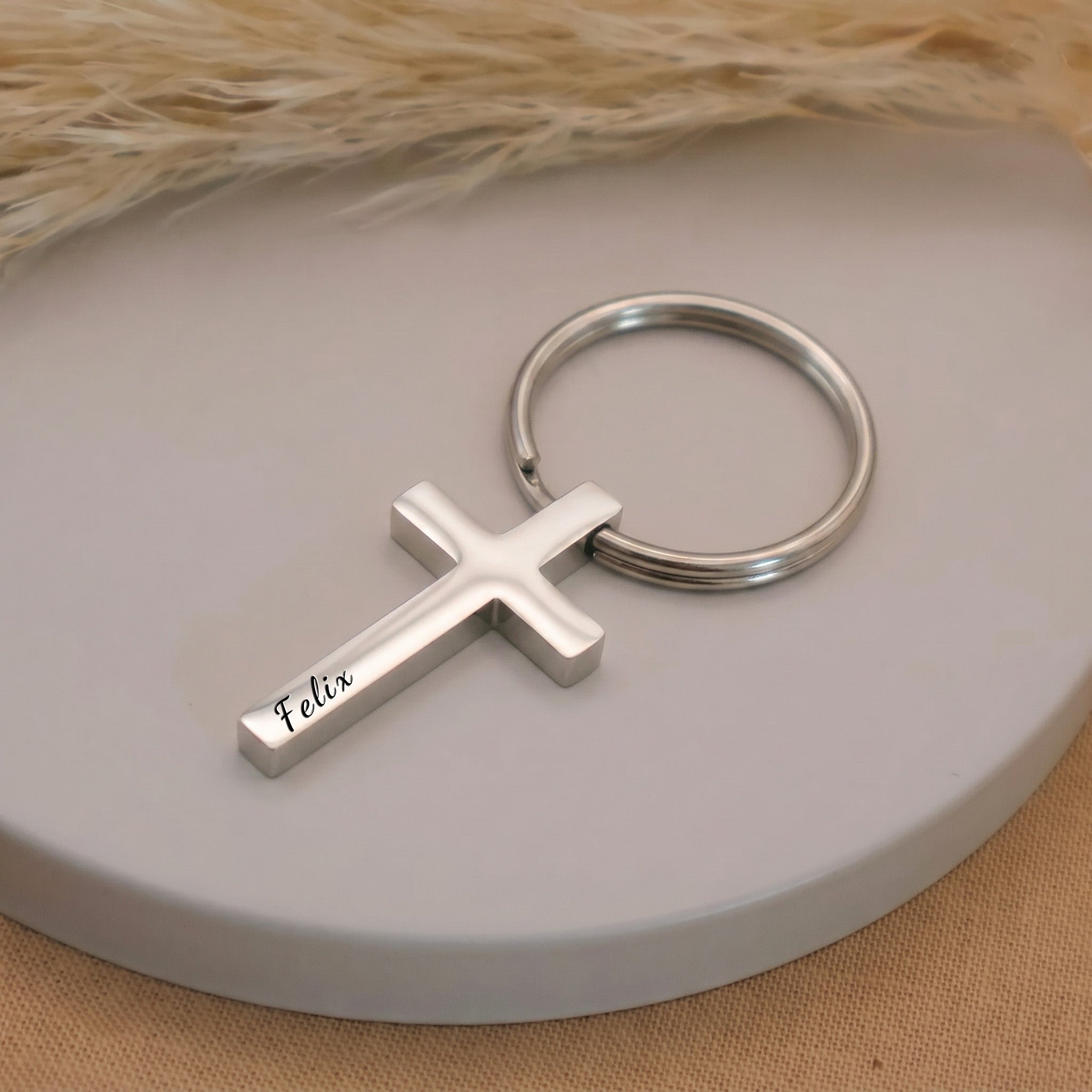 Rhodium pet cross keychain single close-up on a ceramic tray — engraving detail of the hand-drawn portrait and script name on the front face