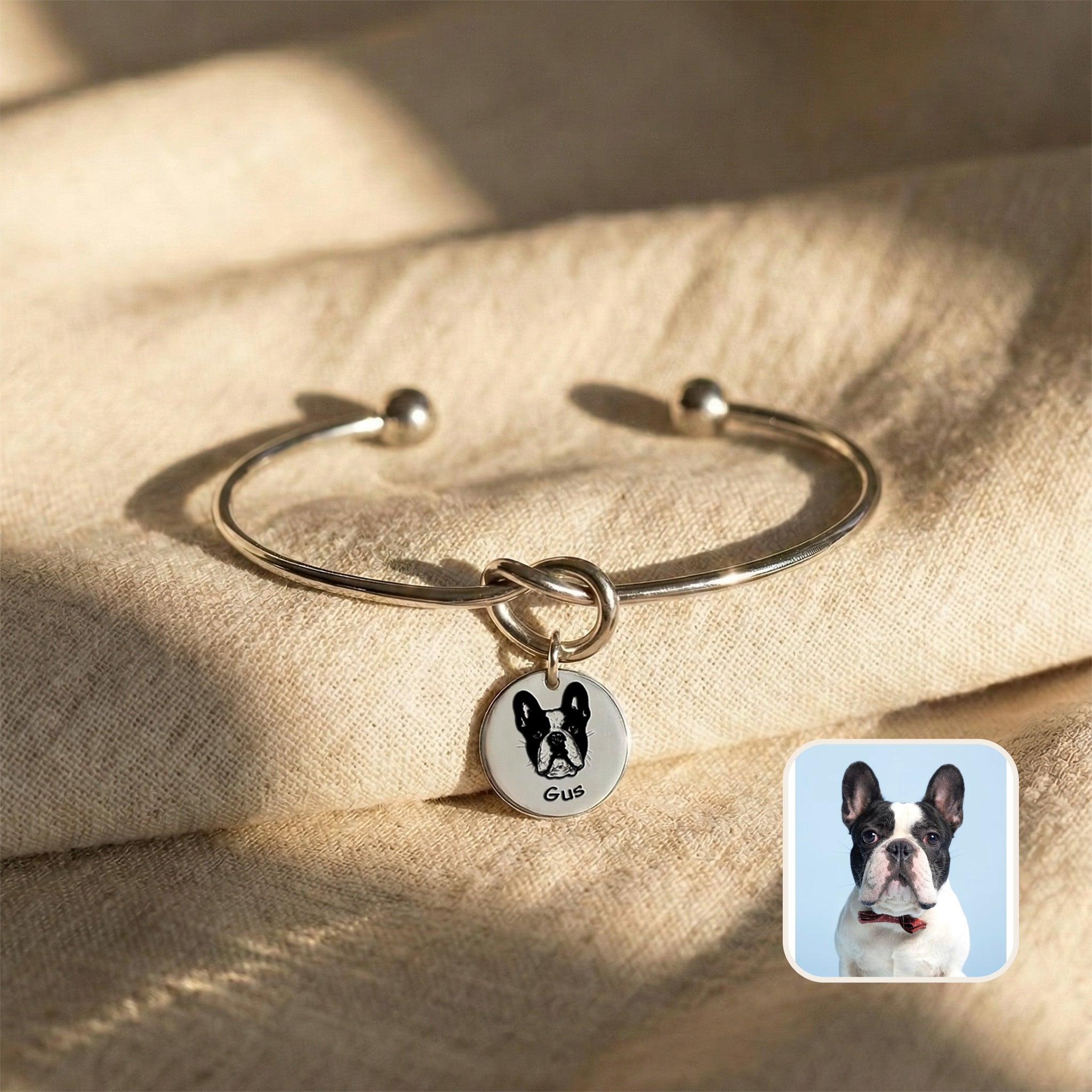 Silver rhodium knot cuff bracelet with engraved French bulldog portrait disc charm on cream fabric, source photo beside