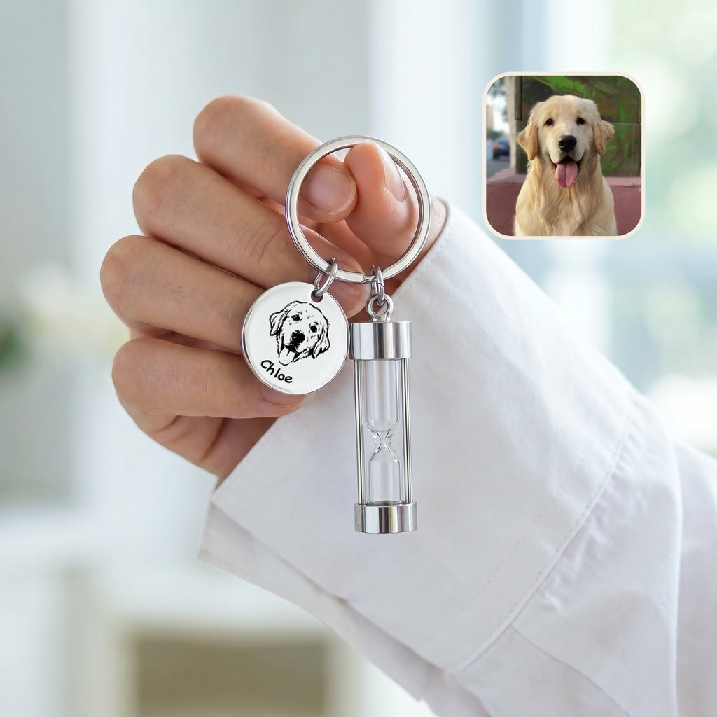 Rhodium-plated pet portrait hourglass keychain held against white sleeve with engraved golden retriever portrait disc and glass hourglass urn, with reference photo inset