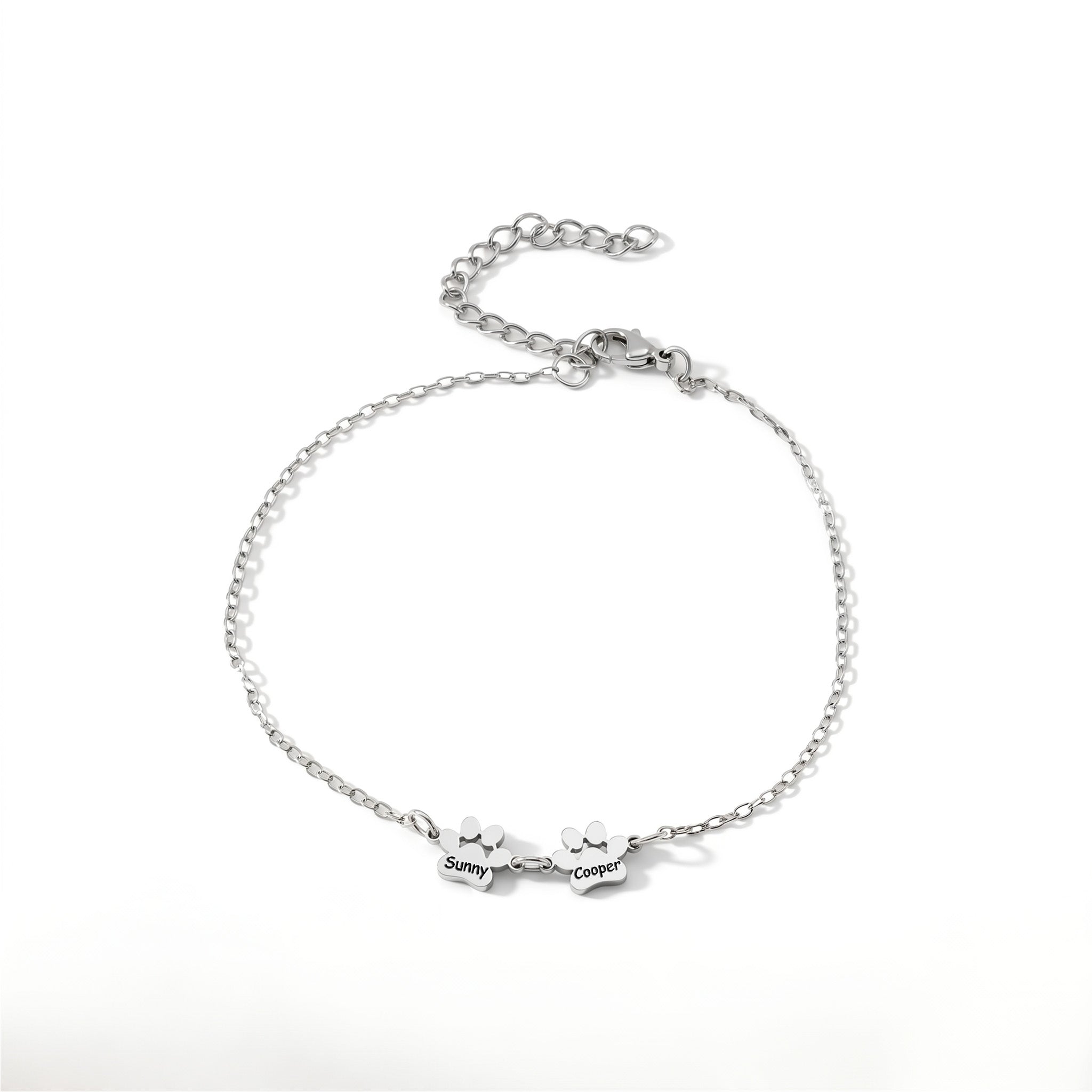 Rhodium paw print name bracelet with two engraved charms on a plain white background