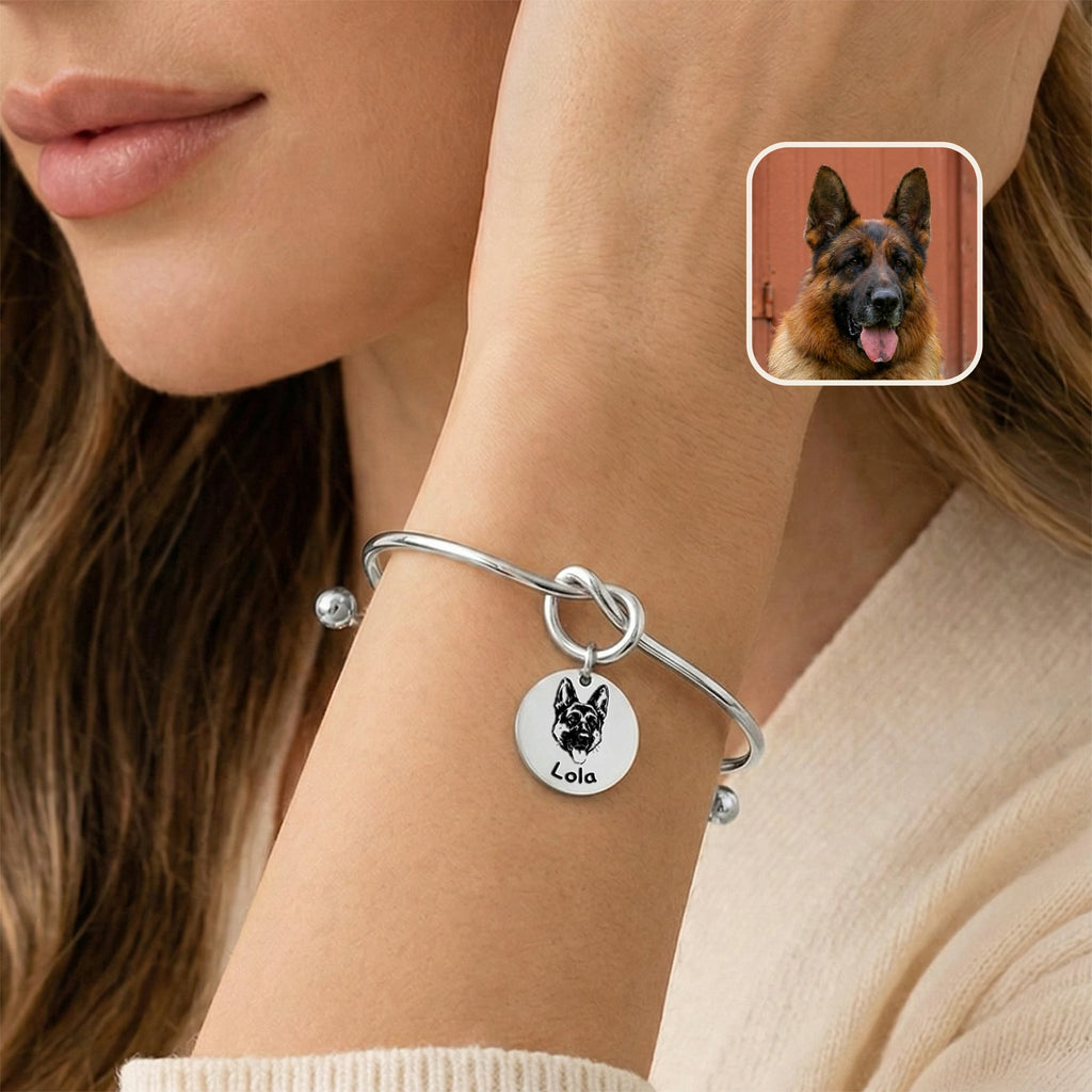 Silver rhodium knot cuff bracelet with engraved German shepherd portrait charm worn on a wrist near the face, photo inset
