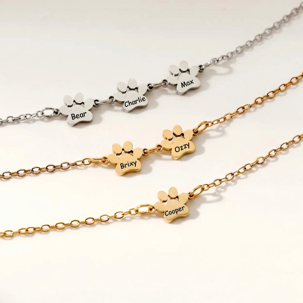 Rhodium and gold paw print bracelets side by side showing both finishes