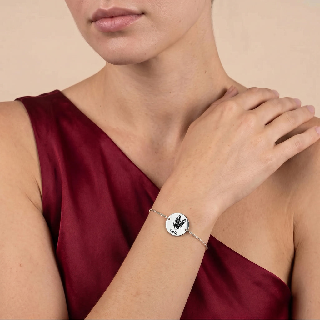 Rhodium pet portrait chain bracelet worn on a wrist against burgundy fabric, hand-drawn French Bulldog portrait on disc