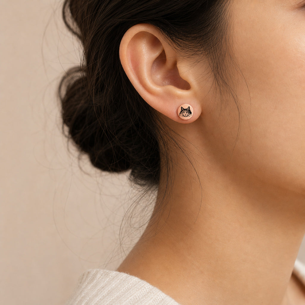 Model wearing a single rose gold pet portrait stud earring with hand-drawn pet face engraving
