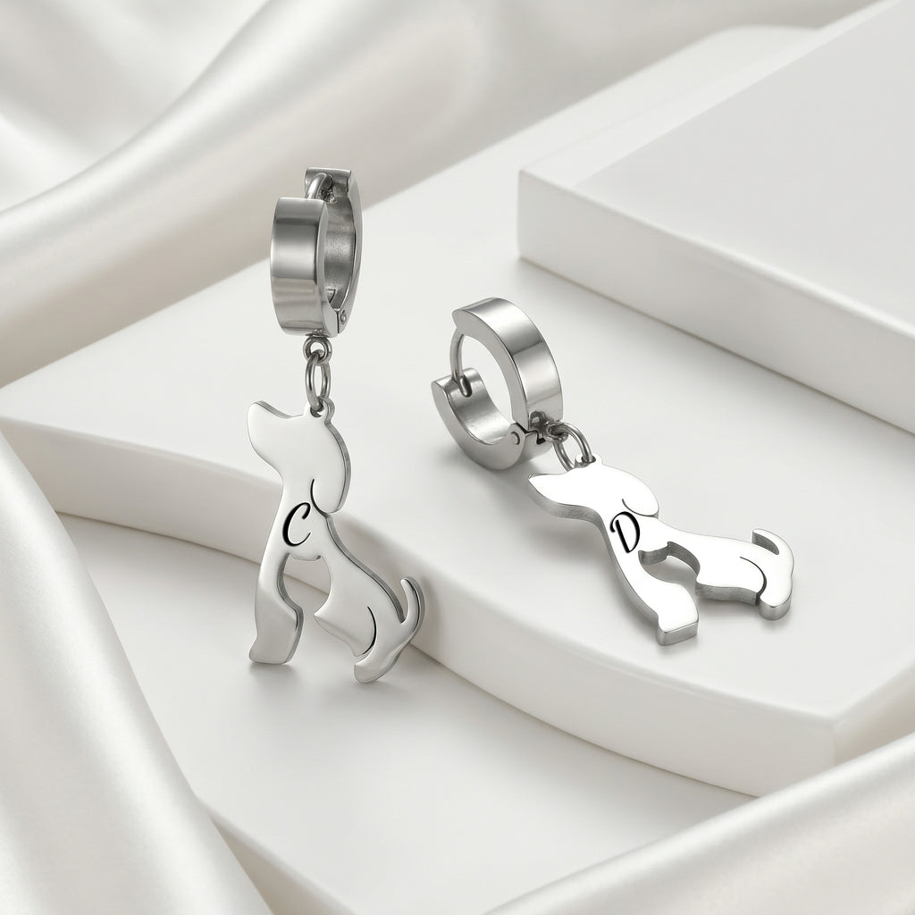 Silver dog-silhouette name earrings displayed on white blocks