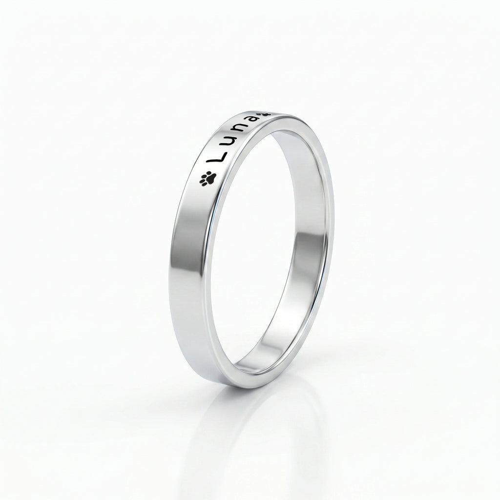 Silver pet name band ring on a near-white background with a soft shadow
