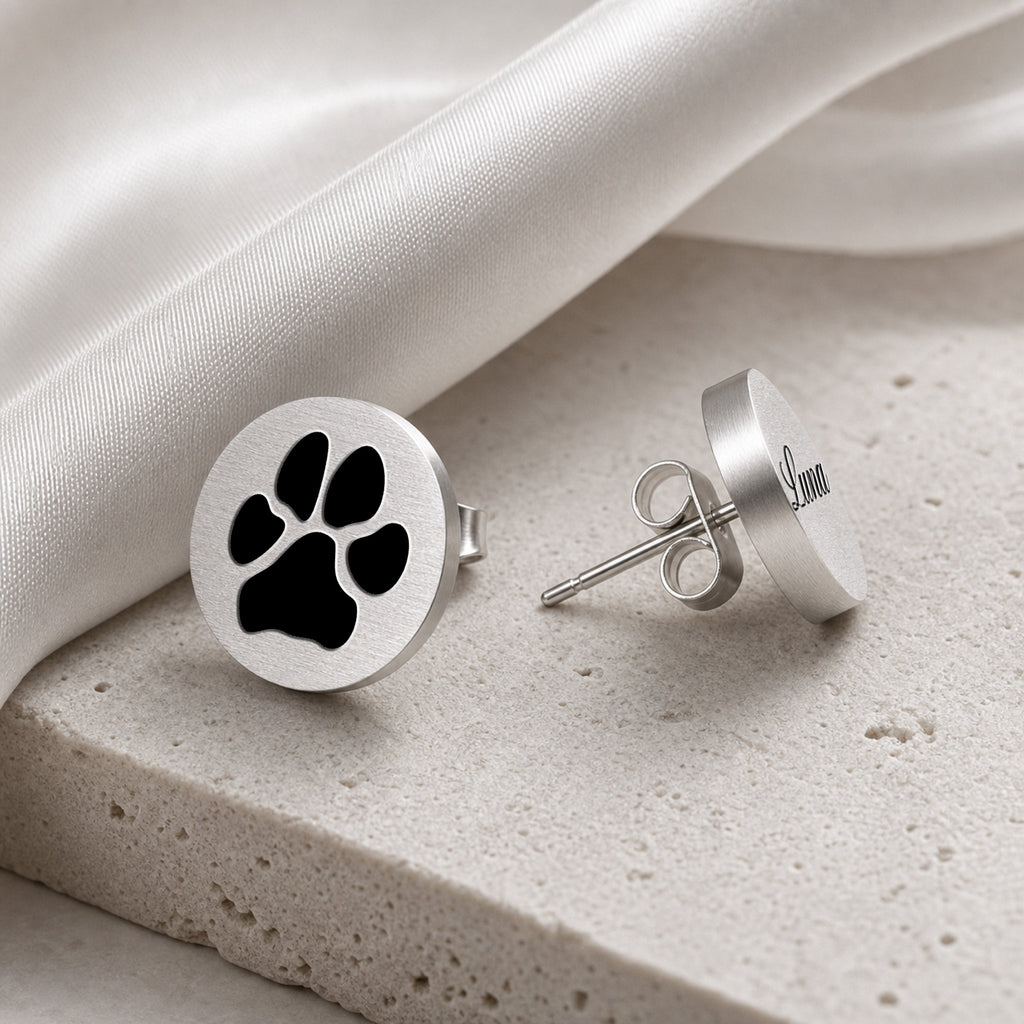 Silver pet name stud earring with script-engraved pet name on a round disc, staged on light stone
