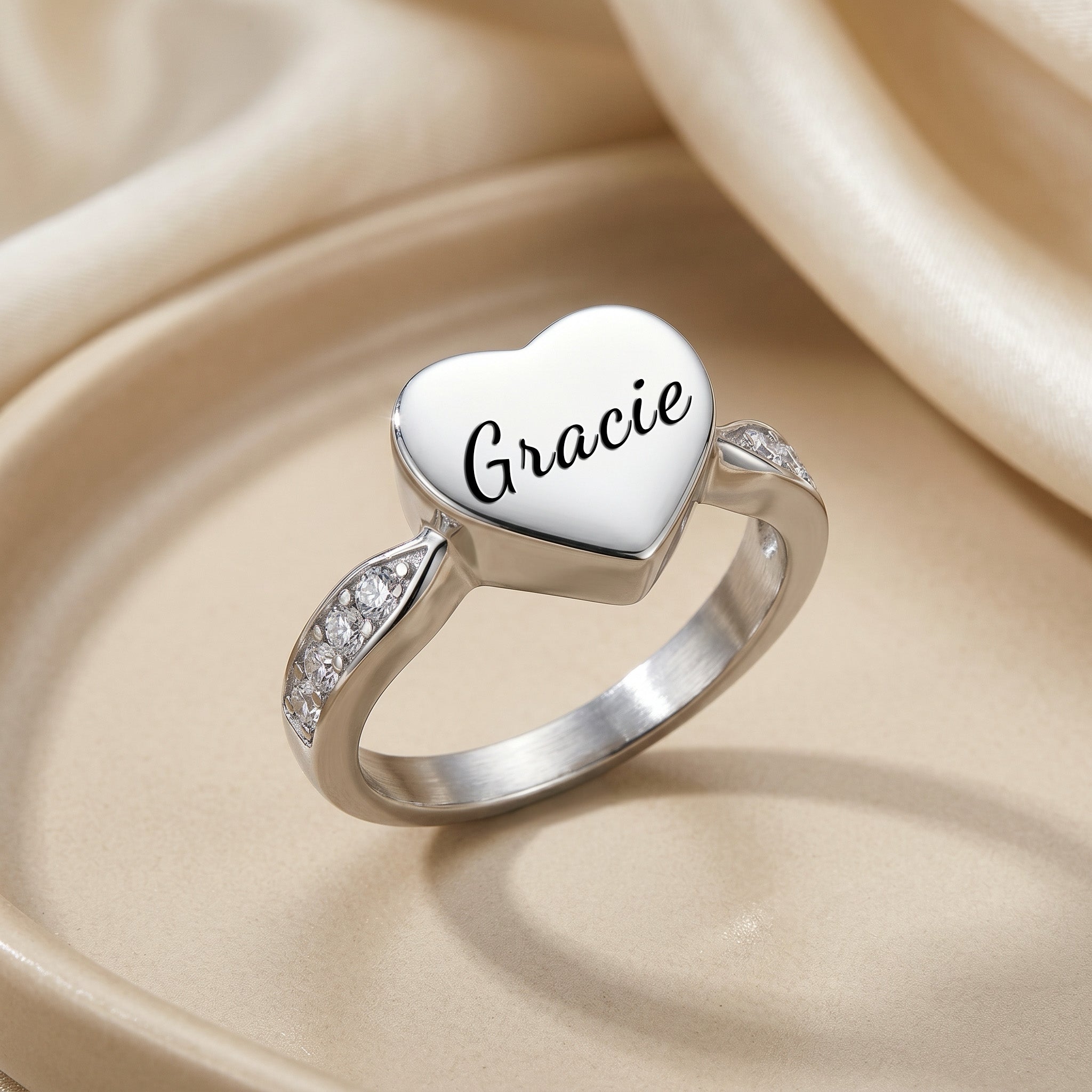 Silver heart urn ring on satin fabric, angled to show heart shape and polished finish