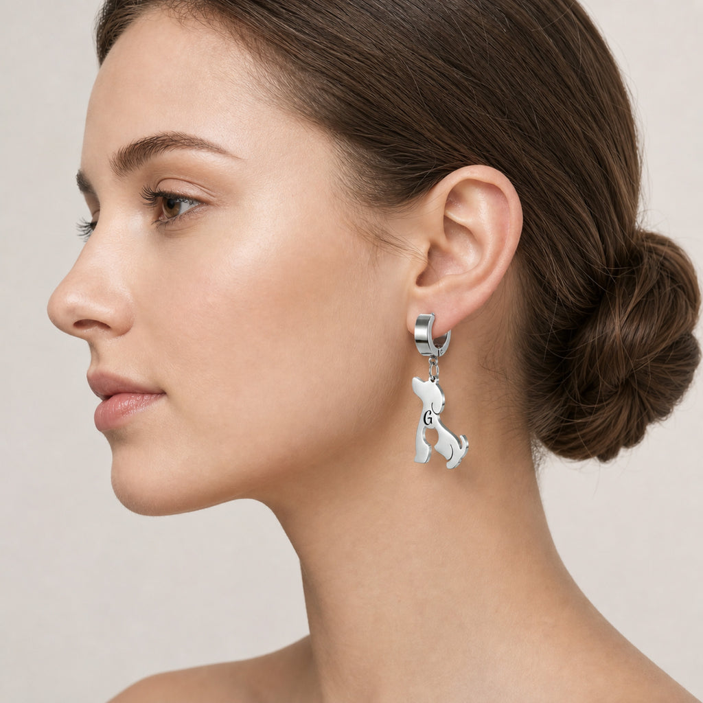 Model with hair in a bun wearing a silver dog-silhouette name earring