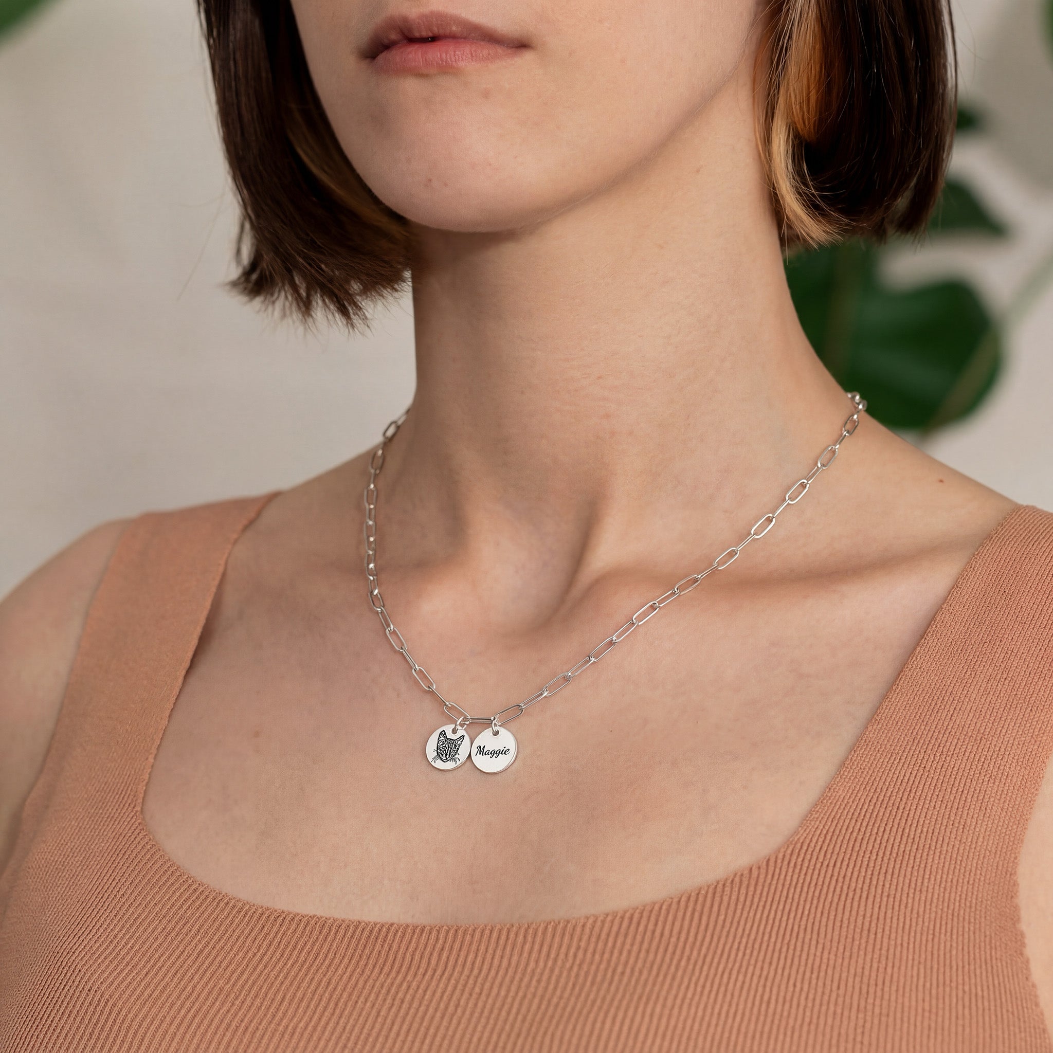 Woman wearing silver paperclip chain necklace with pet portrait and name pendants, lifestyle