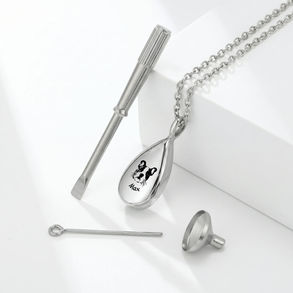 Silver teardrop pet photo urn necklace with dog portrait engraving, styled product shot