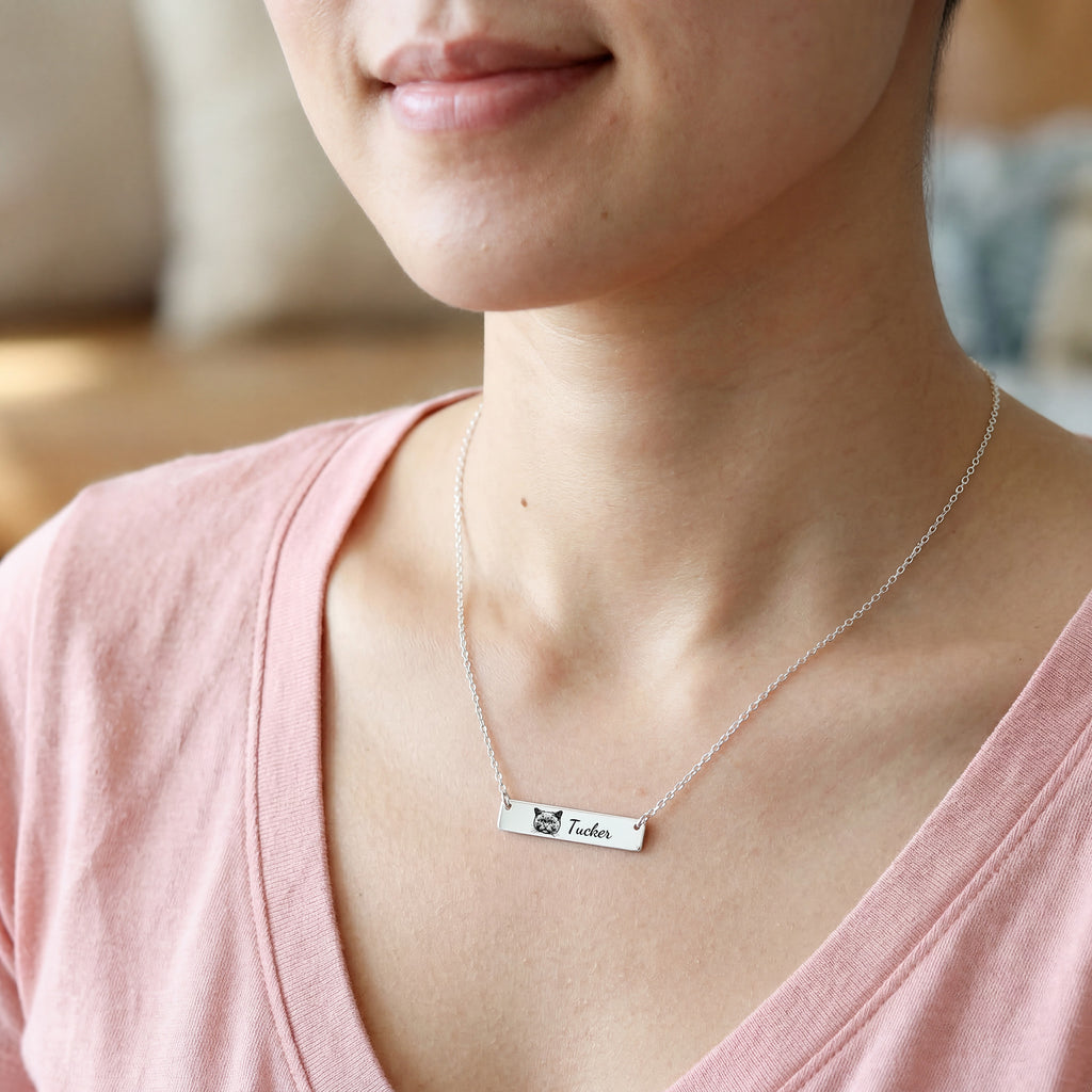 Woman wearing silver pet portrait bar necklace with engraved cat portrait and name Tucker