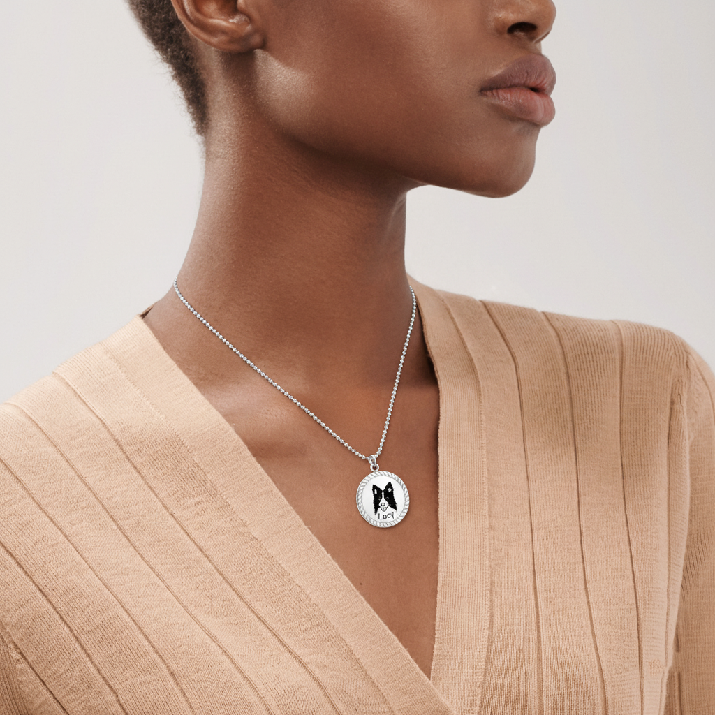 Woman wearing silver rope edge pet portrait pendant over beige V-neck top, lifestyle close-up