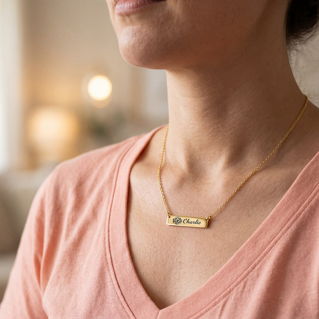 Woman wearing gold pet portrait bar necklace with engraved portrait and name Charlie