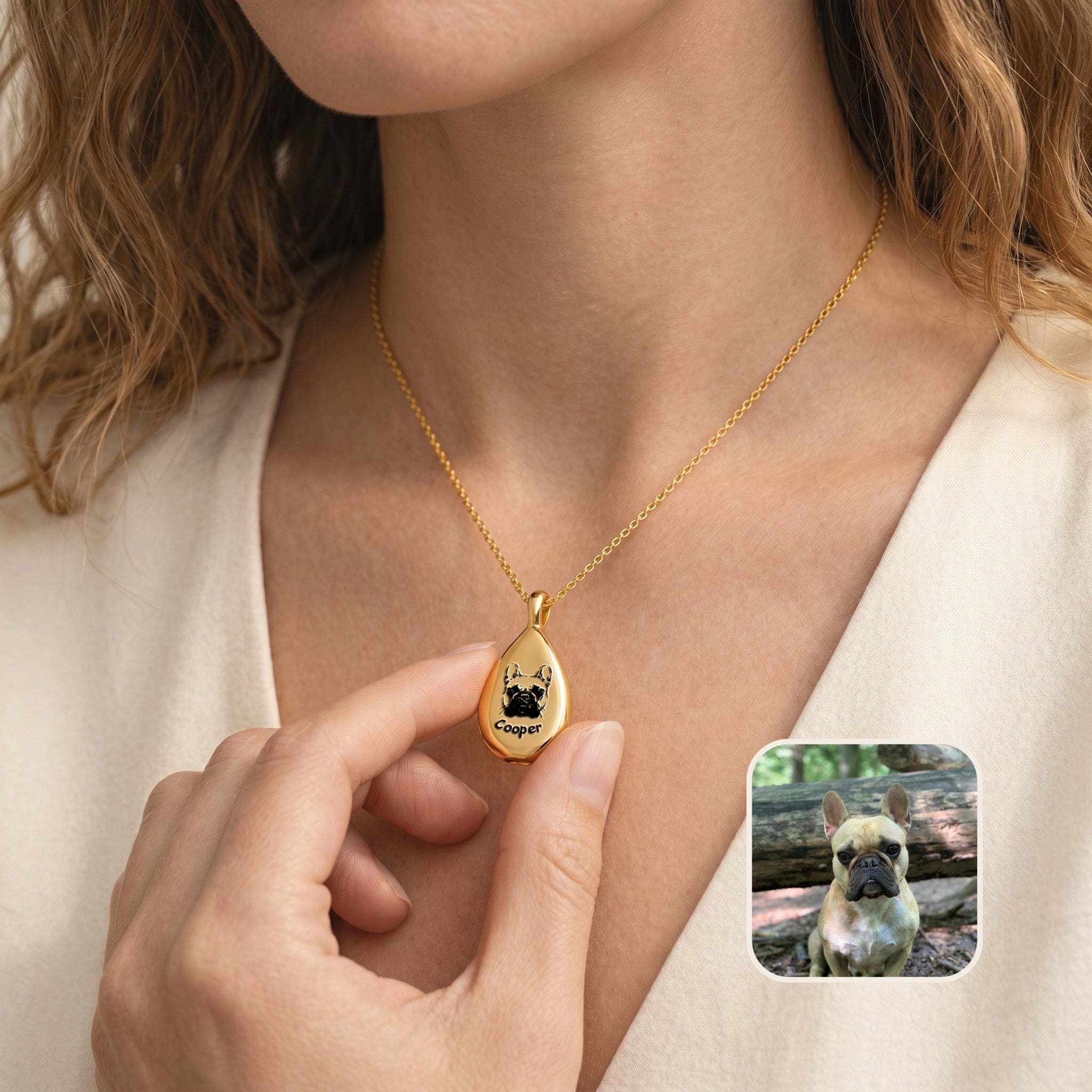 Gold teardrop pet photo urn necklace with hand-drawn dog portrait held in hand, lifestyle view with inset photo