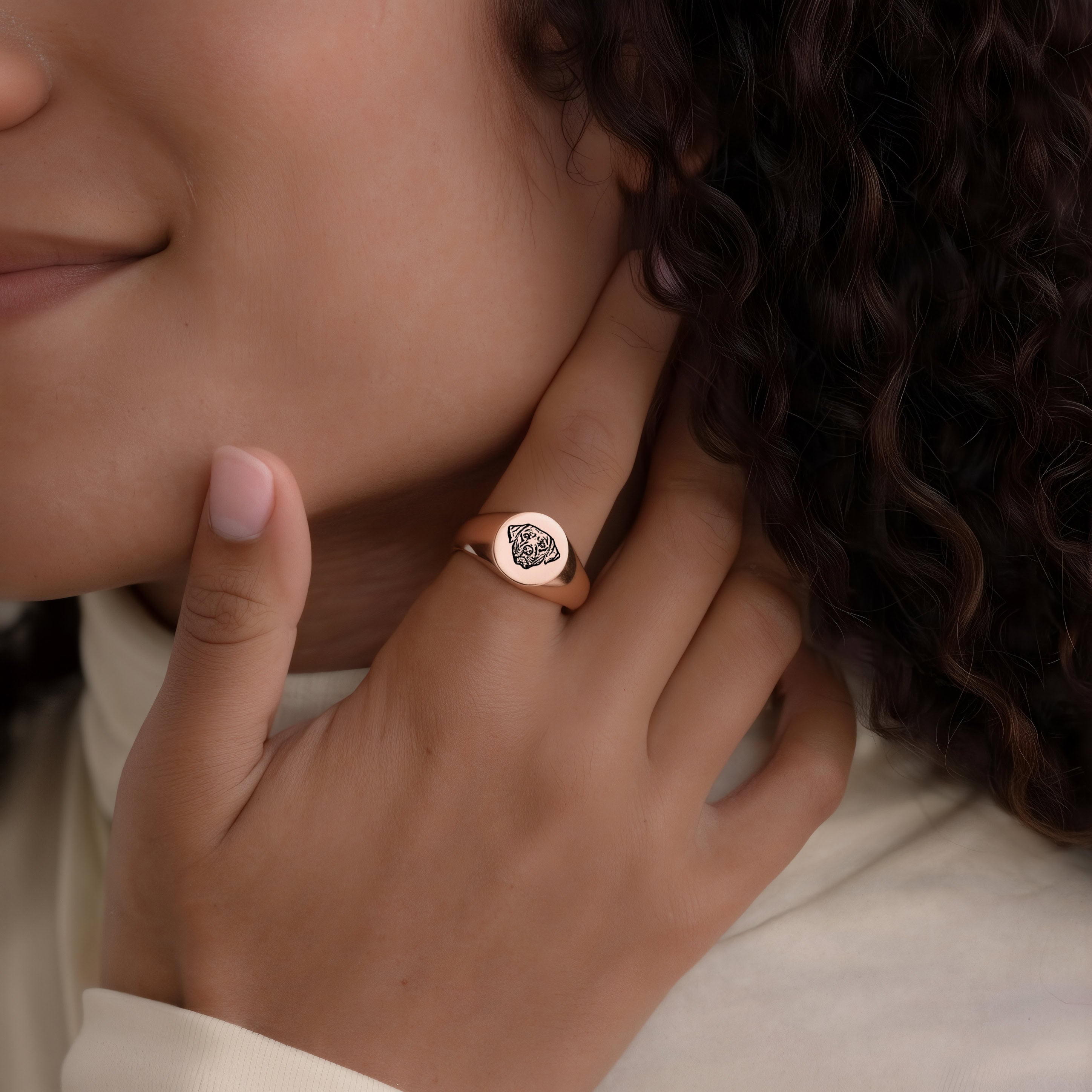 Hand wearing a rose gold pet face ring with engraved portrait, lifestyle close-up
