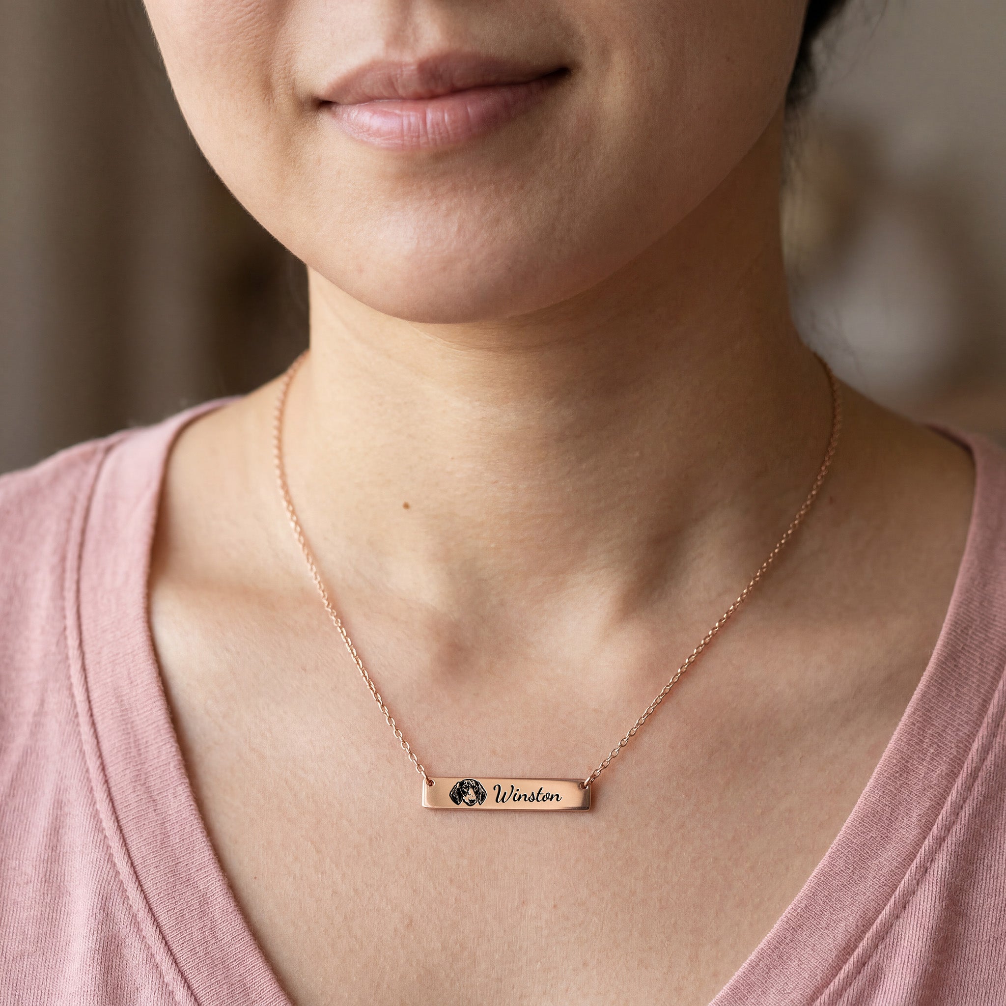Woman wearing rose gold pet portrait bar necklace with engraved portrait and name Winston
