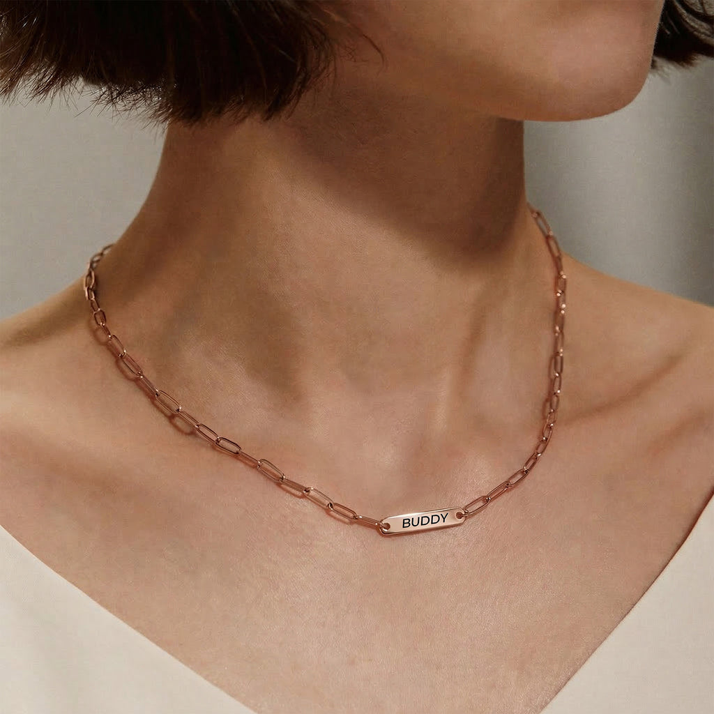 Woman wearing rose gold paperclip chain pet name necklace with one engraved name bar
