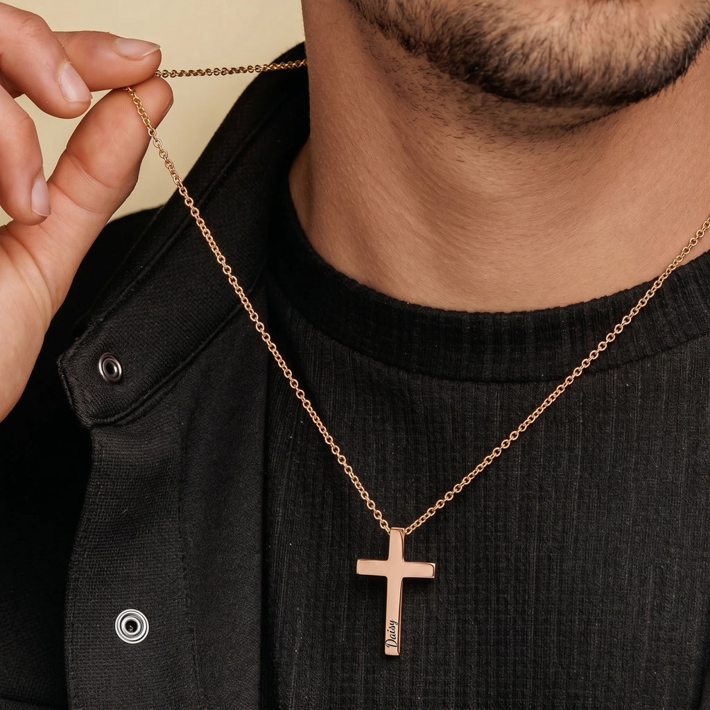 Man wearing rose gold personalized cross necklace over dark outfit