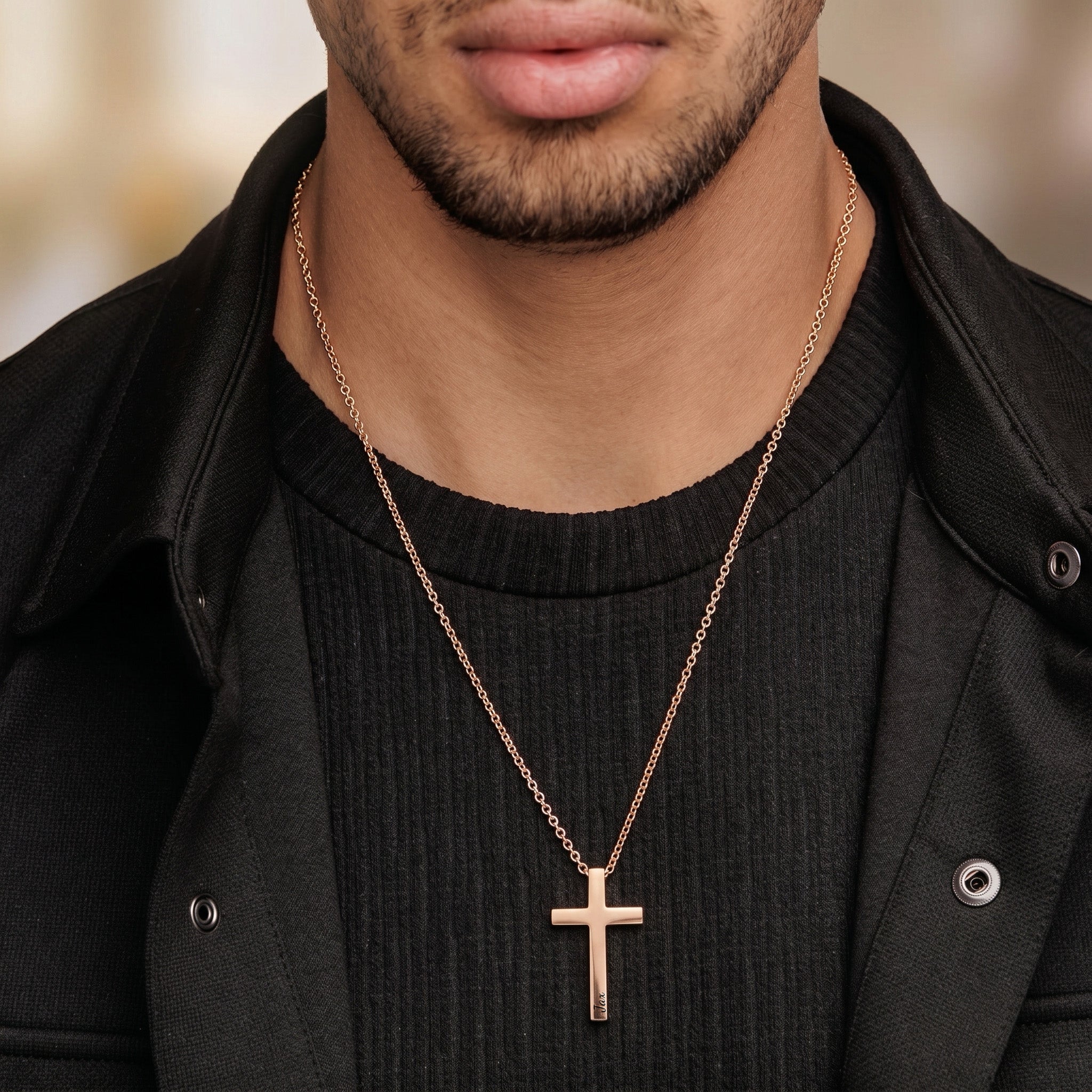 Man wearing rose gold cross necklace with engraved name