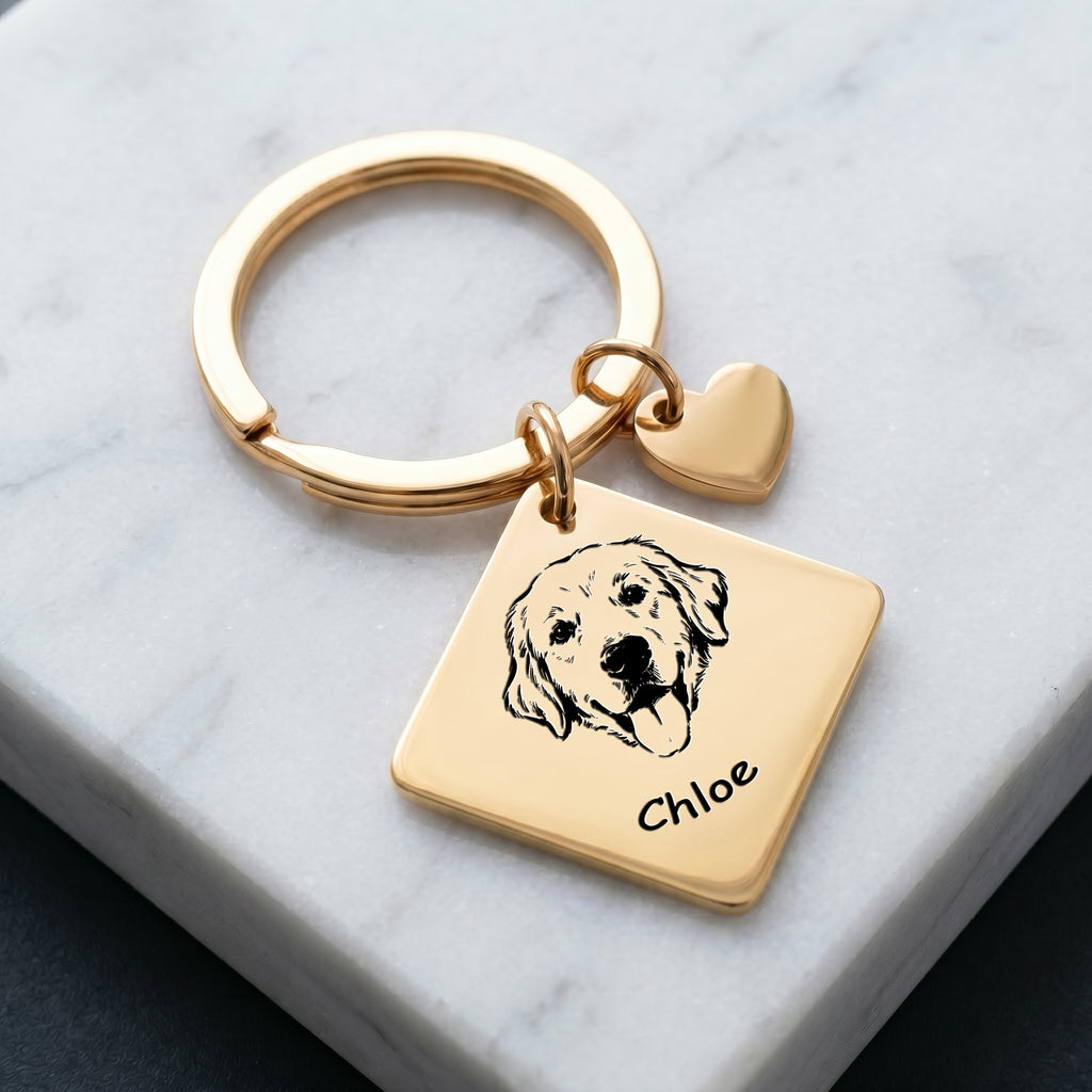 18k gold pet portrait square keychain on marble surface with hand-drawn portrait and pet name engraved
